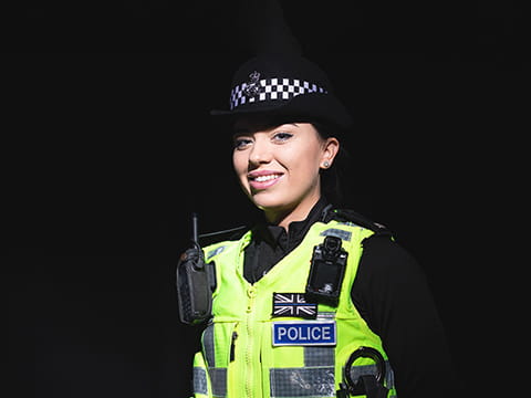 A female police officer against a black background
