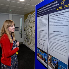 A woman looking at a research poster at a conference