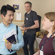 Ming Hung Hsu and Jodie Bloska from CIMTR have a conversation while another member of staff looks on in the background