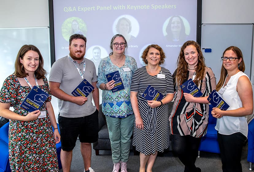 Six keynote presenters posing with information booklets at the PPIE launch in Chelmsford