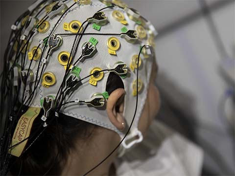 Person in a psychology lab wearing an EEG cap