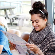 Student reading an open day guide at university