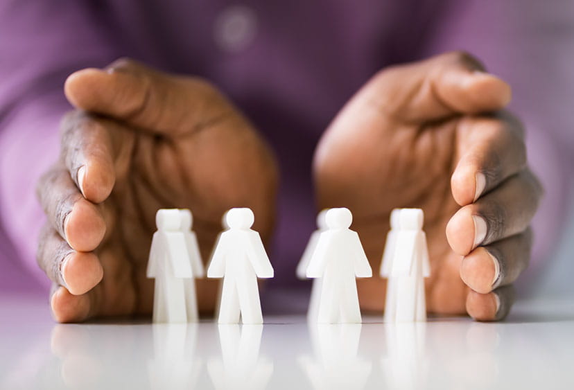 Hands encircling four small figures