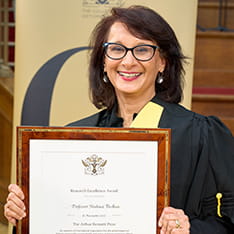 Shahina Pardhan holding her Arthur Bennett Research Excellence Award at the College of Optometrists
