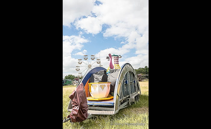 A partially unpacked spinning teacups ride in a field