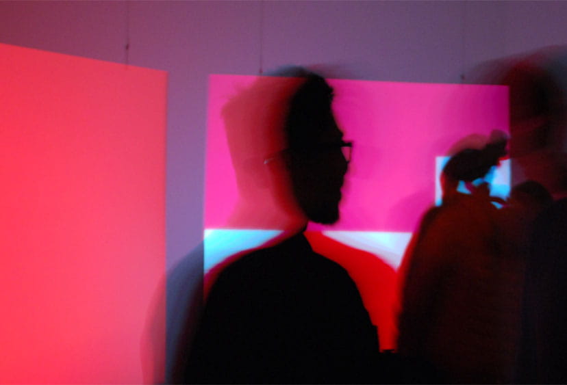 Heads silhouetted against a red background
