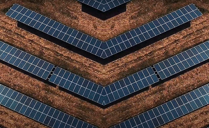 Rows of solar panels in a field, seen from the air