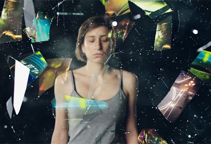 A person with shards of screens exploding around her