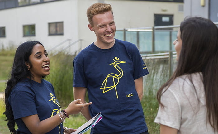 Two student ambassadors talking to a student on ARU's Chelmsford campus