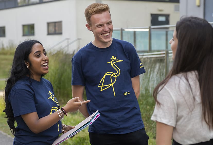Two student ambassadors talking to a student on ARU's Chelmsford campus
