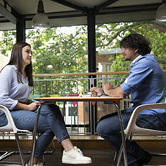 Two people talking opposite each other at a table