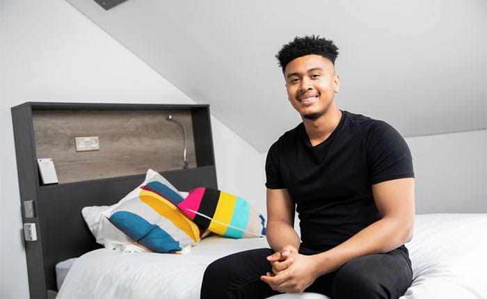 A student sitting on a bed