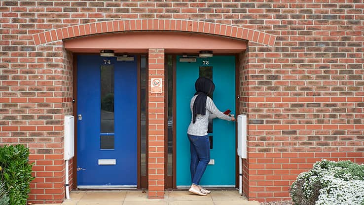 Student outside entrance to Student Village flats