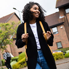 A student with a backpack walking outside