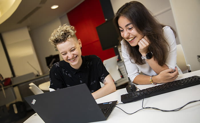 Two students using a laptop
