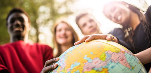 Students looking at a globe
