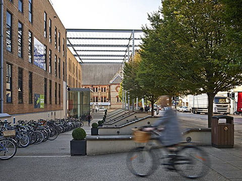 Action shot of a student cycling outside ARU halls of residence in Cambridge