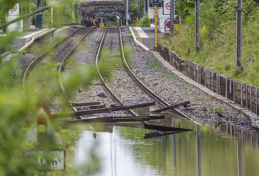 Flooded railway lines with a train in the distance