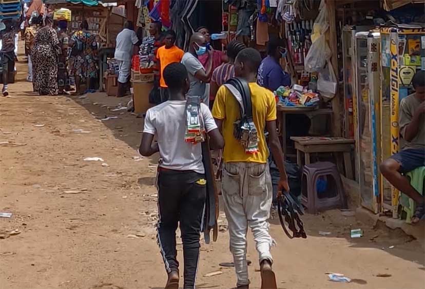 Video still of two young people walking through a market in Ghana