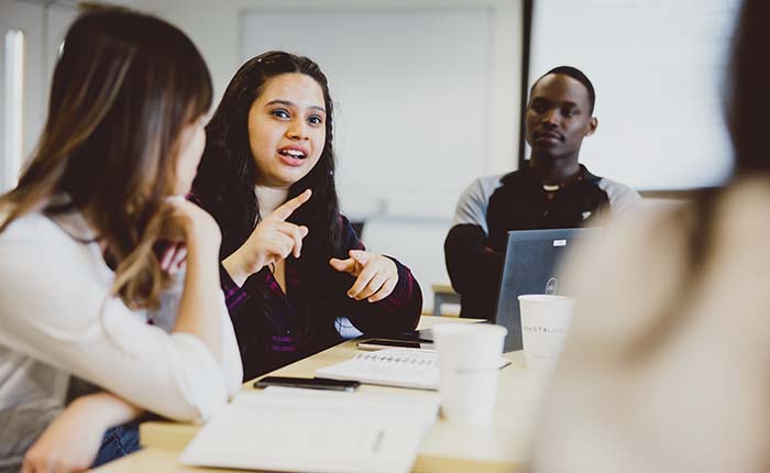 Three students having a discussion in a university classroom
