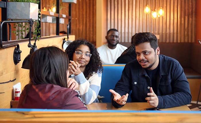 Three university students talking in a social space