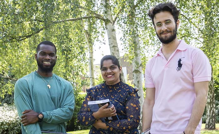Three students pictured outdoors on the ARU Chelmsford campus