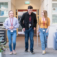 Three Writtle college students walking down a corridor