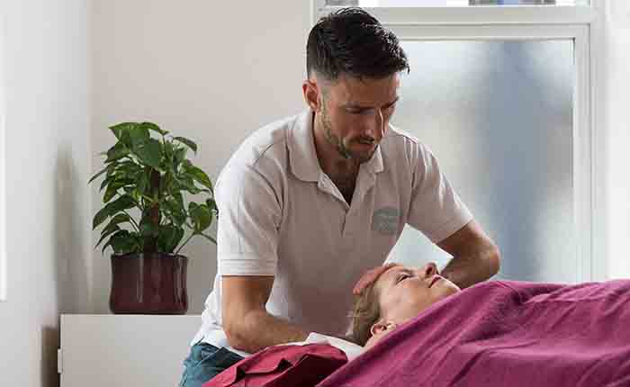 A physiotherapist massaging a client's head