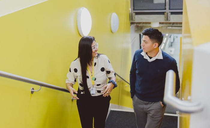 Two international students talking and walking up a set of stairs
