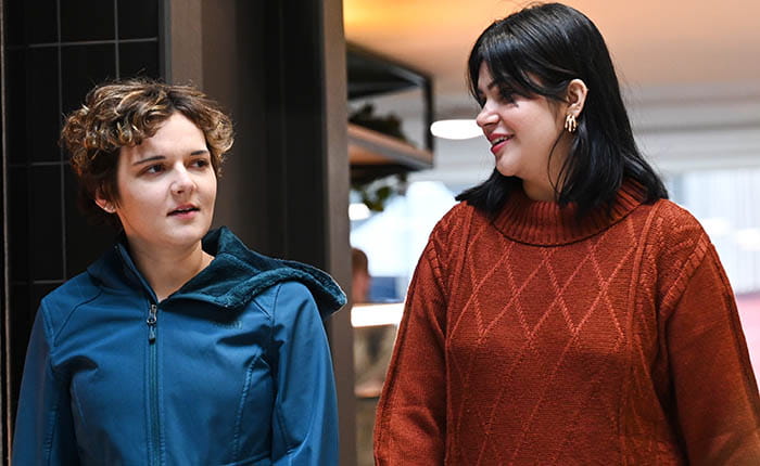 Two students walking and talking at the Eatery on ARU's Cambridge campus