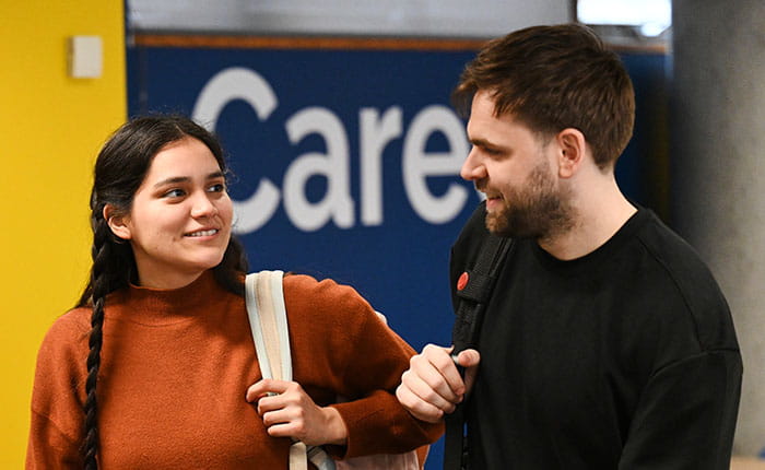 Two students walking and talking by the ARU Career Centre