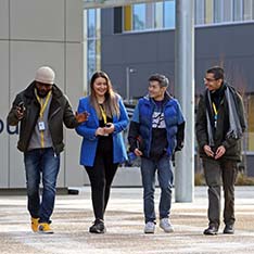 Four students outside the entrance to University House at ARU Peterborough