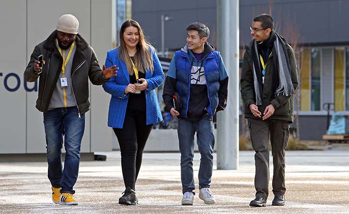 Four students outside the entrance to University House at ARU Peterborough