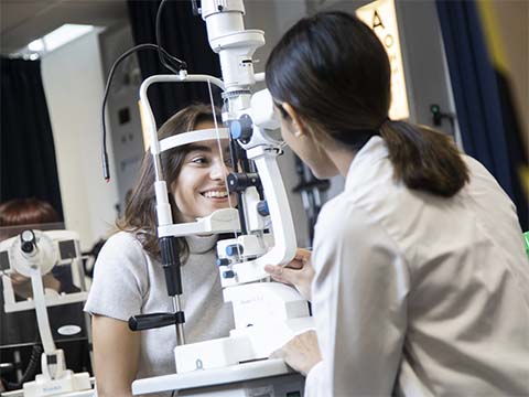 Two students using optometry equipment