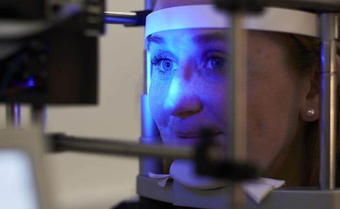 Person with head in a machine having an eye test