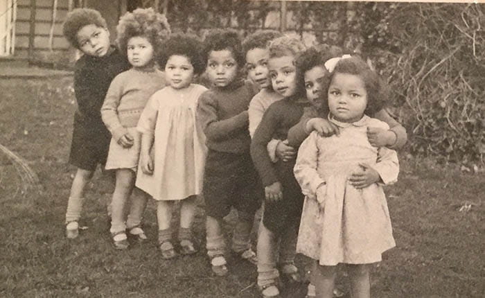 Eight young children standing in a row, photographed in the 1940s
