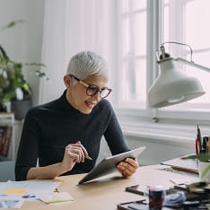 Woman wearing glasses operating a tablet