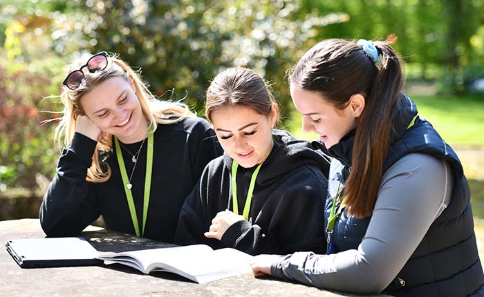 Three students looking at a textbook