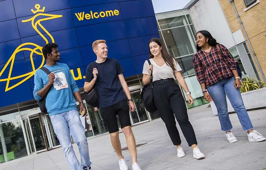 Four students outside main entrance to ARU's Chelmsford campus