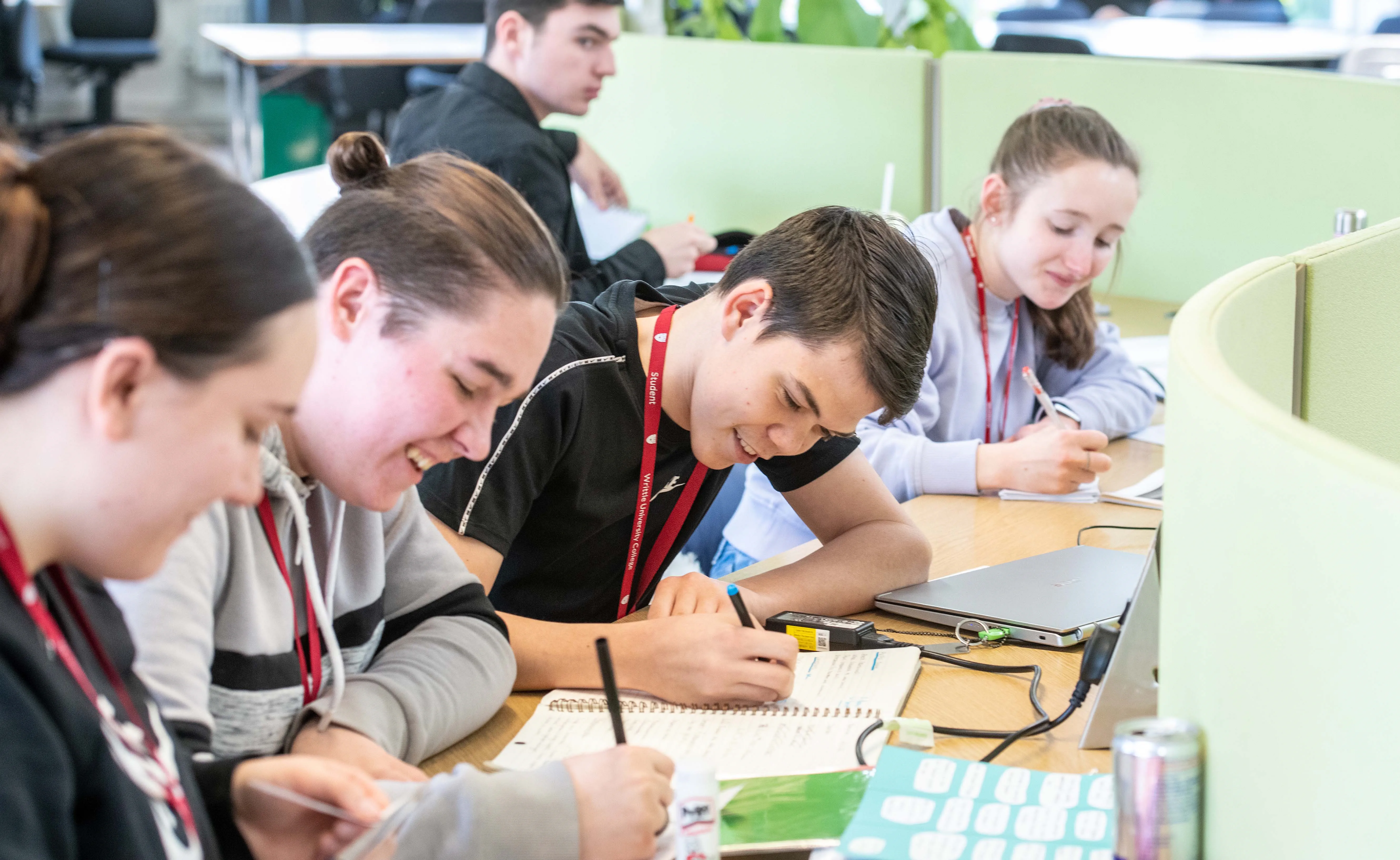Four college students working at a desk in a study area