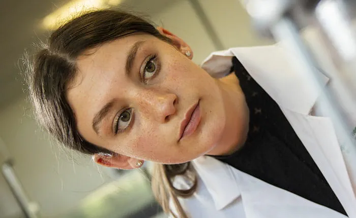 Psychology student Louise wearing a white coat, in a lab