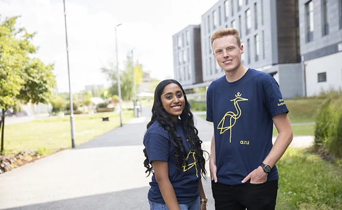 Two Student Ambassadors outside buildings on the ARU Chelmsford campus