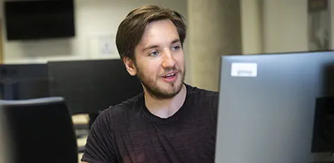 A male student working on a computer