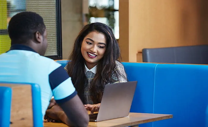Two students looking at a laptop