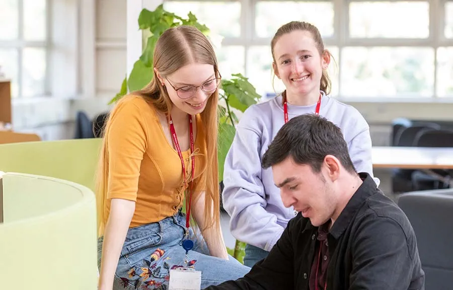 Three college students in an open study area